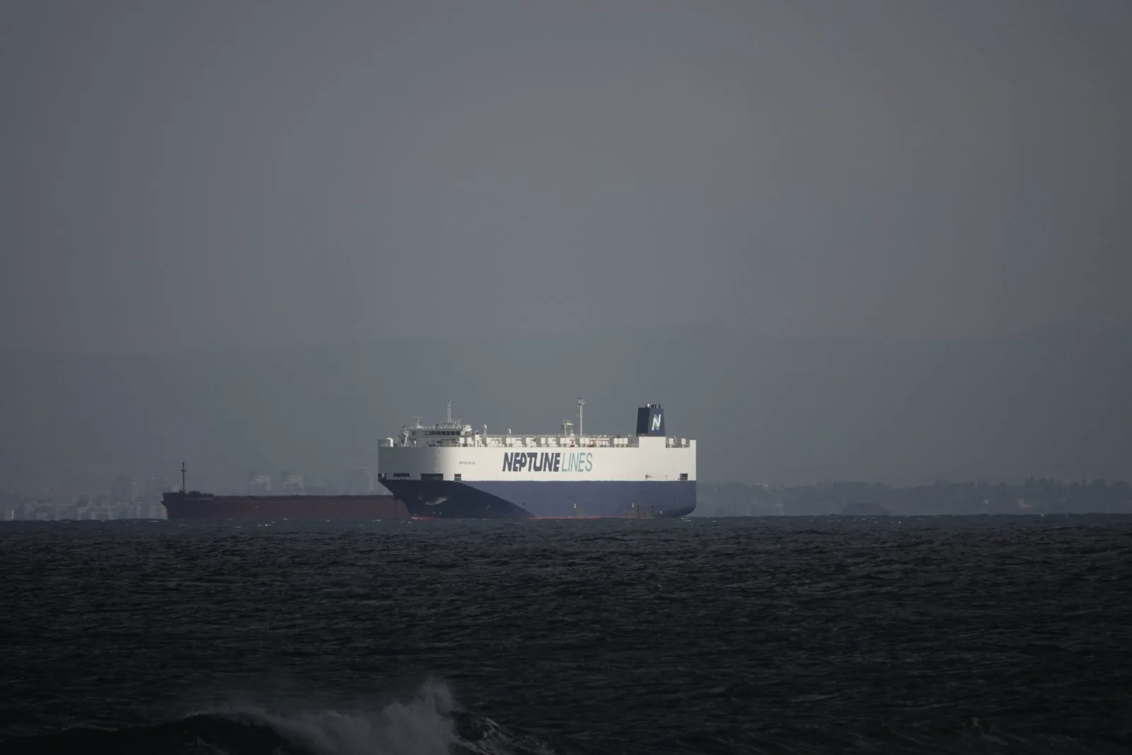 A vehicle carrier ship entering port with finished cars aboard.